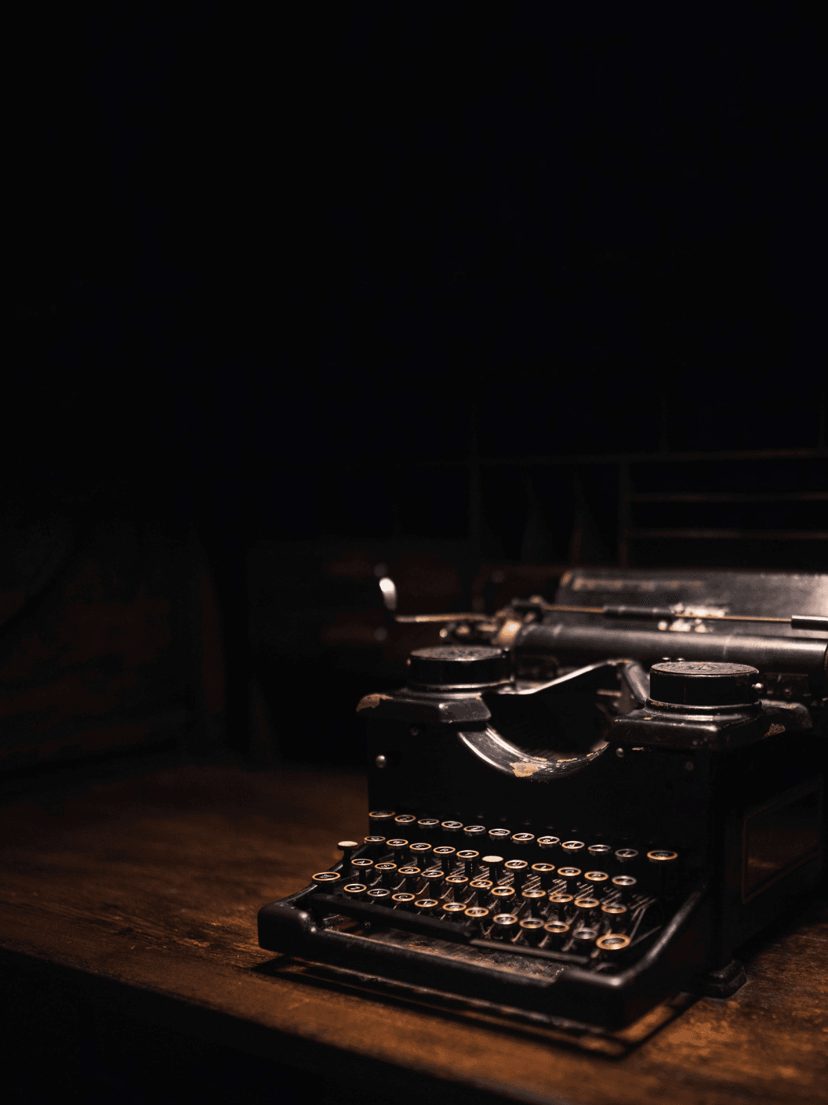 Vintage typewriter lit dramatically on a wooden desk